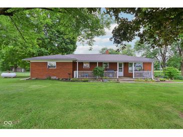 Charming brick home with a covered front porch and a lush green lawn at 9974 N 850 W, Fairland, IN 46126