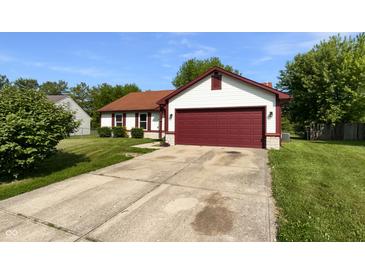 Charming single-story home featuring a red garage door and well-maintained landscaping at 11722 Hartland Dr, Indianapolis, IN 46229