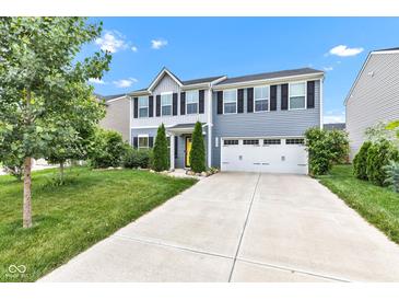 Inviting two-story home with a vibrant yellow door, attached two-car garage, and landscaped front yard at 13844 N Cardonia Dr, Camby, IN 46113