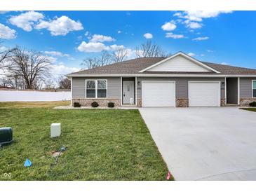 Charming townhouse featuring gray siding, a two-car garage, and a well-manicured lawn at 1612 Paula Dr, Columbus, IN 47201