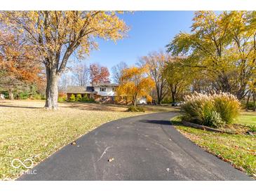 Charming home featuring a long driveway and lush landscaping with mature trees at 2457 N Centerline Rd, Franklin, IN 46131