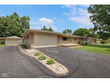 Charming single-story home with brick and stone details, attached garage, and well-maintained landscaping at 406 W Mcgregor Rd, Indianapolis, IN 46217