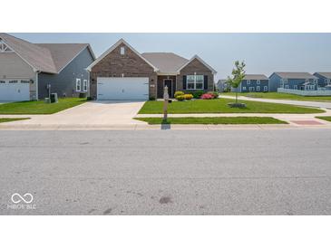 Charming single-story brick home with a well-manicured lawn and two car garage in a suburban neighborhood at 9001 Fitzgerald Dr, Indianapolis, IN 46239