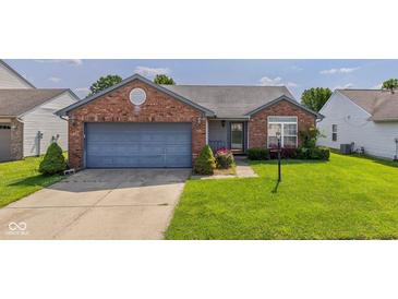 Charming single-story brick home featuring an attached garage, well-manicured lawn, and welcoming front entrance at 1547 Millridge Dr, Greenwood, IN 46143