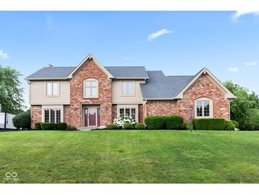 Charming two-story home with a brick facade, manicured lawn, and beautiful landscaping at 1826 Spruce Dr, Carmel, IN 46033