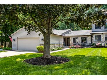 Charming home exterior with stone accents, a well-manicured lawn and an attached two-car garage at 289 Sandbrook Dr, Noblesville, IN 46062