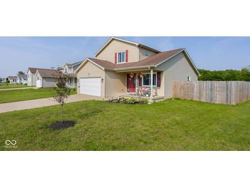 Charming two-story home with a well-maintained lawn and a cozy front porch featuring seasonal decorations at 4605 Clairmont Dr, Columbus, IN 47203
