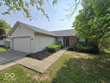 Charming single-story home with a well-maintained lawn, attached garage, and beautiful curb appeal at 5825 Sapelo Dr, Indianapolis, IN 46237