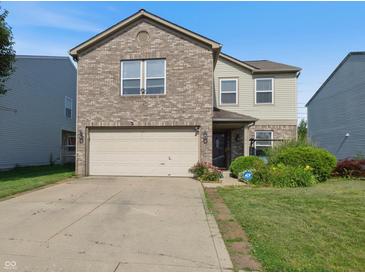 Charming two-story home featuring a brick facade, attached garage, and manicured front yard at 6608 Sonesta Dr, Indianapolis, IN 46217