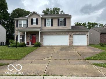 Charming two-story home with a two-car garage and a well-manicured lawn at 6730 Nw Shanghai Cir, Indianapolis, IN 46268
