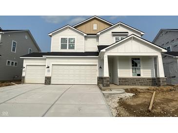 New construction two-story home boasting a three car garage, white siding, and contrasting stone foundation at 7151 Firestone Rd, Whitestown, IN 46052