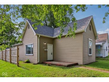 Charming single-story home with tan siding and a well-manicured lawn, showcasing curb appeal at 1106 N Sheffield Ave, Indianapolis, IN 46222