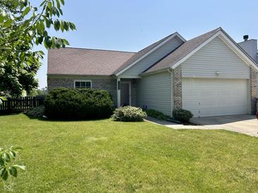 Charming single-Gathering home with a well-manicured lawn, lush bushes, and an attached two-car garage at 12307 Chiseled Stone Dr, Fishers, IN 46037