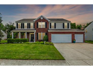 Inviting two-story home boasting a manicured lawn, three-car garage and brick and siding facade with classic shutters at 1343 Turfway Dr, Avon, IN 46123