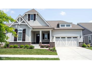 Charming home featuring a well-manicured lawn, a two-car garage, and a welcoming front porch at 1590 Birchfield Dr, Westfield, IN 46074