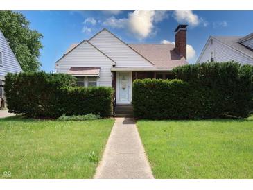 Charming home with mature landscaping, a walkway leading to the front door, and a well-maintained lawn at 2309 Maple St, Columbus, IN 47201