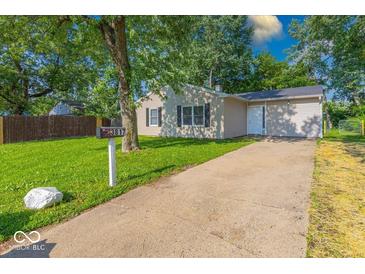 Charming one-story home with a well-maintained lawn, concrete driveway, and inviting curb appeal at 3817 Strathmore Dr, Indianapolis, IN 46235