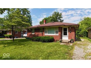 Charming single-story red brick home with a well-manicured lawn and lovely front yard landscaping at 3922 N Irvington Ave, Indianapolis, IN 46226