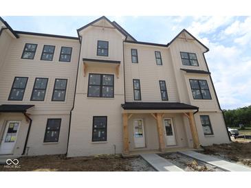 Modern townhome with cream colored exterior, black window trim and black roof at 4151 Barrel Ln, Westfield, IN 46062