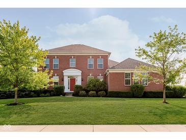 Beautiful two-story brick home with a manicured lawn and bright red front door at 4617 S Cobblestone Dr, Zionsville, IN 46077
