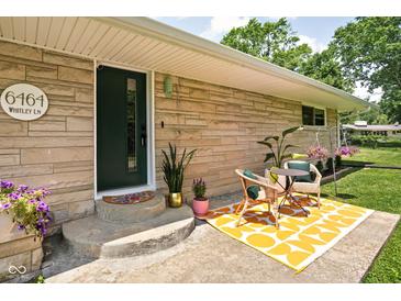 Charming front entrance featuring a seating area and green door at 6464 Whitley Ln, Indianapolis, IN 46260