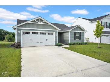 Charming single-Gathering home boasts a well-maintained lawn, a two-car garage, and classic architectural details at 7171 E Rising Sun S Cir, Camby, IN 46113