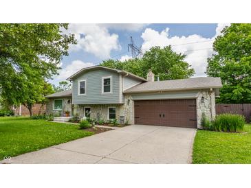 Charming two-story home featuring a stone facade, attached two-car garage, and well-maintained landscaping at 8015 Ridgegate East Dr, Indianapolis, IN 46268