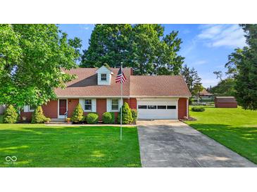 Charming brick ranch home with a well-manicured lawn and an American flag at 1010 Maple St, Greenwood, IN 46142