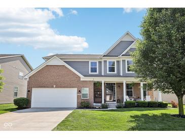 Charming two-story home featuring a brick facade, attached two car garage, and inviting front porch at 123 Bentree Blvd, Danville, IN 46122