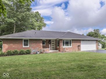 Charming brick ranch home featuring a well-manicured lawn and attached one car garage at 1504 Mcclure Rd, Columbus, IN 47201