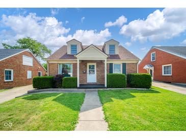 Charming brick home featuring a manicured lawn, tidy bushes, and a sidewalk leading to the front door at 2908 Sherman St, Anderson, IN 46016