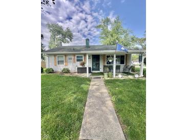 Charming single-story home with a covered front porch and well-manicured lawn with mature trees at 3101 Danbury Rd, Indianapolis, IN 46222