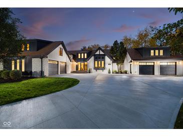 Stunning home exterior featuring a circular driveway and three-car garage with modern black-and-white Tudor style at 3549 W 131St St, Carmel, IN 46032