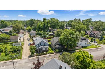 An aerial shot of a peaceful neighborhood, featuring tree-lined streets and well-maintained homes under a sunny sky at 4715 E New York St, Indianapolis, IN 46201