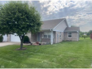Charming single-story home with a well-maintained lawn, mature tree, and neutral brick exterior at 5632 Spring Mist Cir, Indianapolis, IN 46237