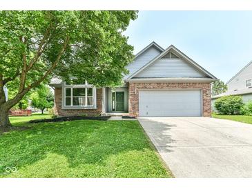 Charming brick and siding home with a well-manicured lawn and a two-car garage at 7168 Camwell Dr, Indianapolis, IN 46268