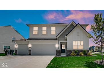 Charming two-story home featuring a three-car garage, well-manicured lawn, and stylish architectural details at 8690 Lester Pl, Pendleton, IN 46064