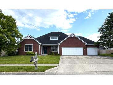 Charming brick home with a well-manicured lawn, a two-car garage and a welcoming front yard at 1019 White Oak Dr, Plainfield, IN 46168