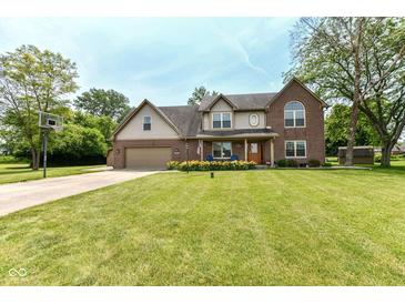 Charming two-story brick home with manicured lawn and basketball hoop on driveway at 1031 W Morning Walk Dr, Greenfield, IN 46140