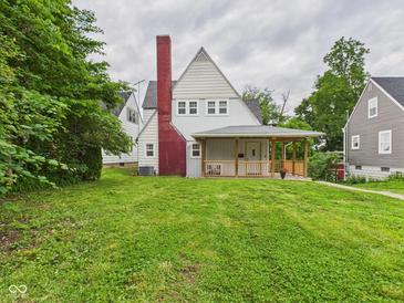 Charming home with a red brick chimney, covered porch, and well-maintained lawn at 1910 W 10Th St, Anderson, IN 46016