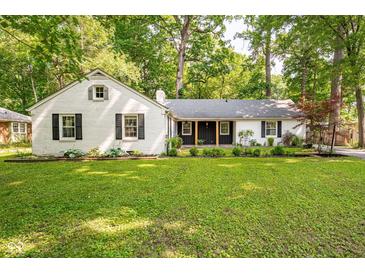 Charming one-story home featuring a well manicured lawn and a beautiful white painted brick exterior at 3312 W 42Nd St, Indianapolis, IN 46228