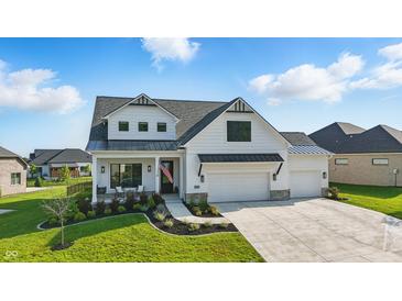 Stunning two-story home featuring white siding, black accents, a covered porch, and a three-car garage at 5668 Champion Way, Greenwood, IN 46143