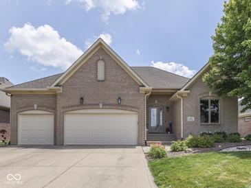 Charming brick home featuring a three-car garage, manicured lawn, and a welcoming front entrance at 6525 Carolina Blvd, Indianapolis, IN 46217