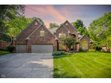 Charming brick home boasts a manicured lawn, mature trees, and a three-car garage, perfect for Gathering living at 7648 W Williamswood Dr, New Palestine, IN 46163