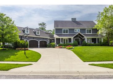 Beautiful two-story home showcasing dark siding, metal roof accents, and a spacious driveway leading to a three-car garage at 10974 Harbor Bay Dr, Fishers, IN 46040