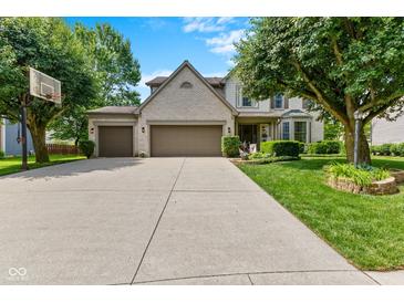 Charming two-story home featuring a spacious driveway, well-maintained lawn, and a three-car garage at 12043 Searay Dr, Indianapolis, IN 46236