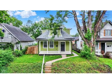 Charming green home with a welcoming front porch and well-maintained lawn and landscaping at 1338 N Parker Ave, Indianapolis, IN 46201