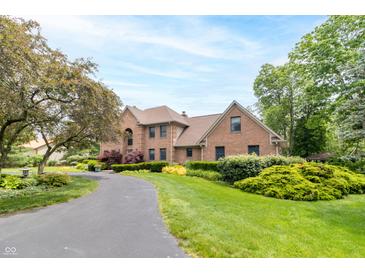 Beautiful brick home with mature trees, lush landscaping and a paved driveway leading to the front entrance at 1497 N 200 W, Greenfield, IN 46140