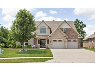 Charming two-story home featuring a manicured lawn, mature tree, and a blend of brick and stone accents at 5194 Orahood Ct, Plainfield, IN 46168
