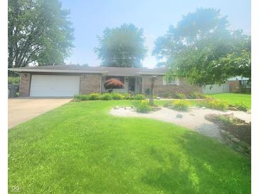 Charming brick ranch home with well-manicured lawn and colorful flowerbeds at 623 Chariot Ln, Indianapolis, IN 46227